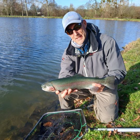 Jolie truite du réservoir capturée à l'aide d'un worm aps rouge ramené rapidement